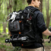 Person wearing a heavily loaded backpack with various equipment in a forest setting
